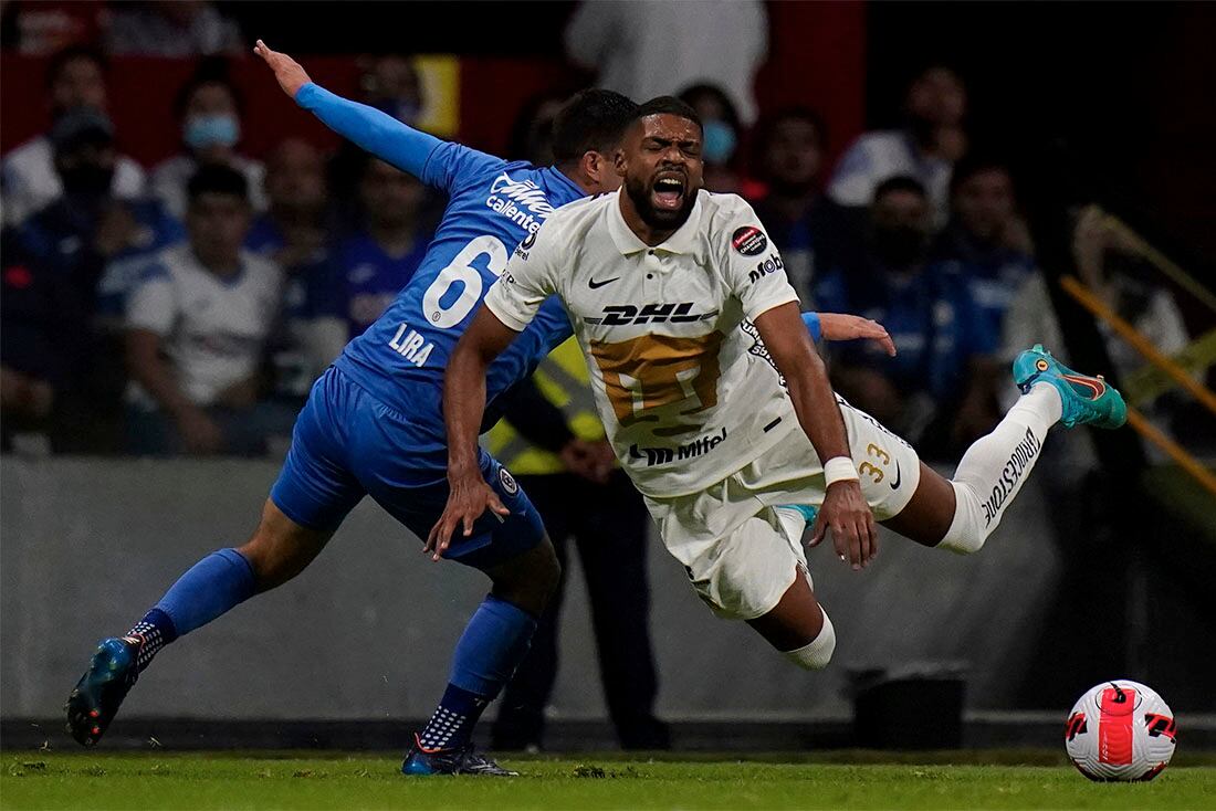 Diogo de Oliveira. del Pumas de México (delante), recibe una falta de Erik Lira, del Cruz Azul mexicano, durante un juego de la Liga de Campeones de la CONCACAF, en la Ciudad de México, el 12 de abril de 2022. (AP Foto/Eduardo Verdugo)