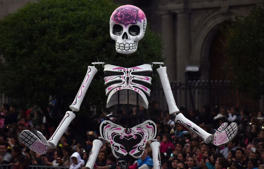 
Foto: AFP | Una marioneta de calavera pasa entre el público apostado en el Zócalo de la ciudad de México.
   