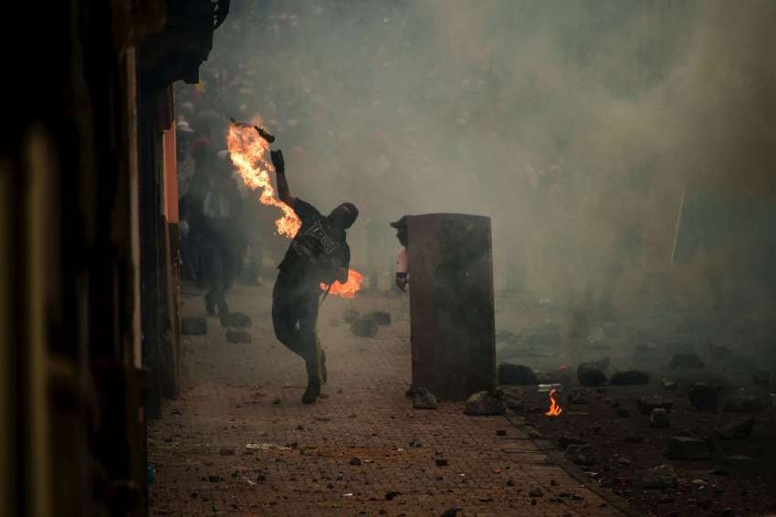 
Foto: AFP | Un manifestante arroja un cóctel molotov a la policía mientras miles marchan contra el presidente ecuatoriano, Lenin Moreno.
   