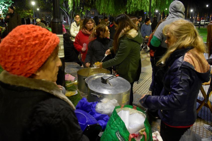 
Plaza Chile. Como todos los lunes, se sirve la cena para quienes lo necesitan. Esta vez el menú es locro, para celebrar el 25 de Mayo. | Diego Parés / Los Andes
   