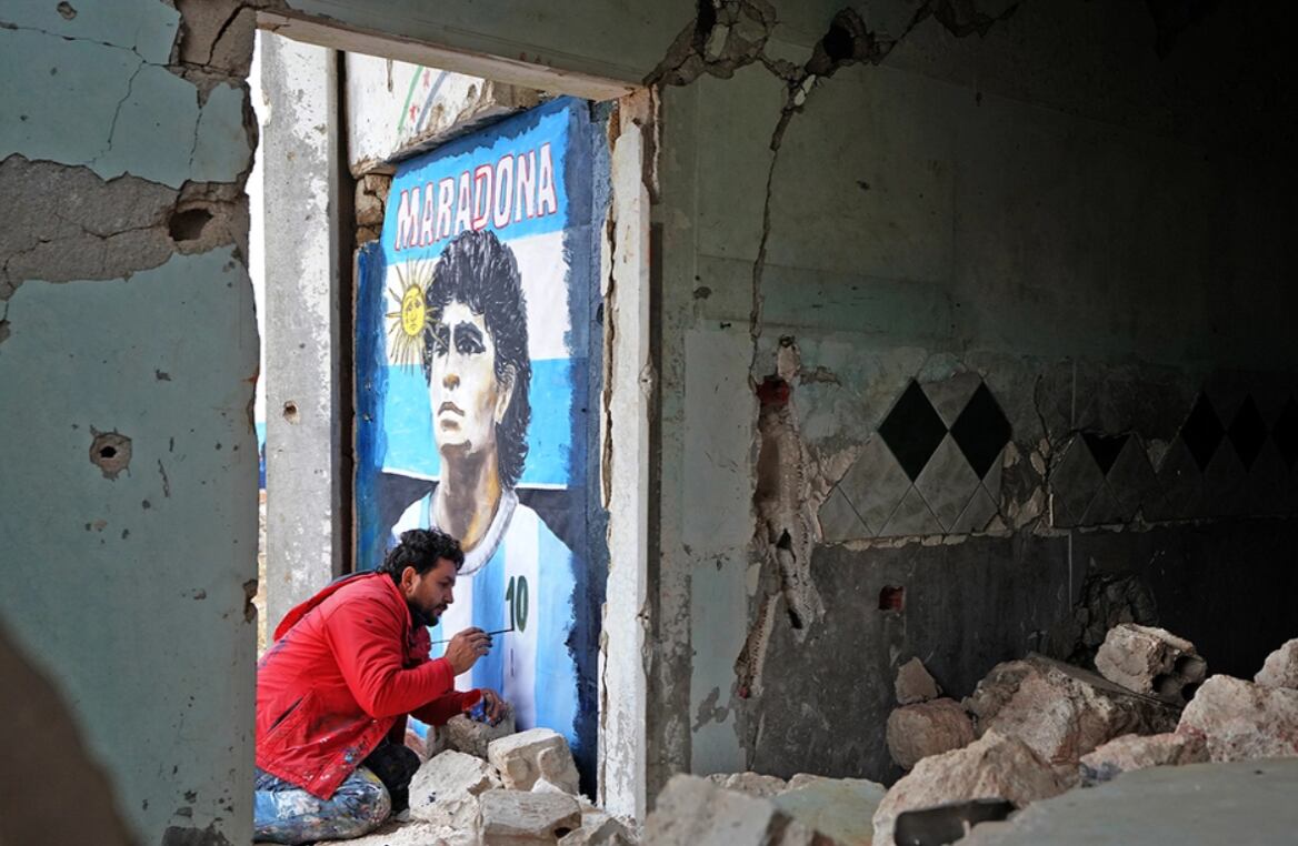 Un artista sirio realizó un mural con el rostro del '10' en una ciudad en ruinas. Foto AFP.