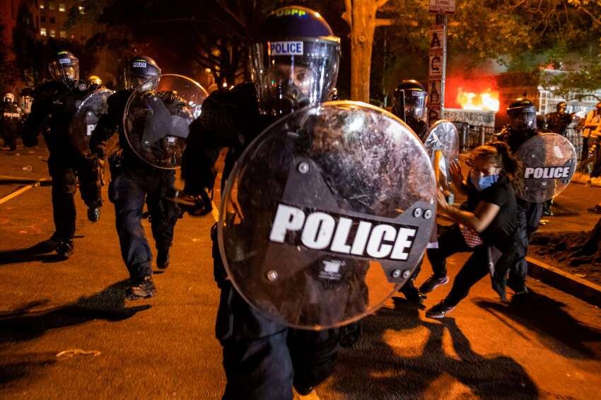 
AFP | Un oficial de policía ataca mientras las personas protestan por la muerte de George Floyd a manos de la policía de Minneapolis frente a la Casa Blanca en Washington, DC.
   