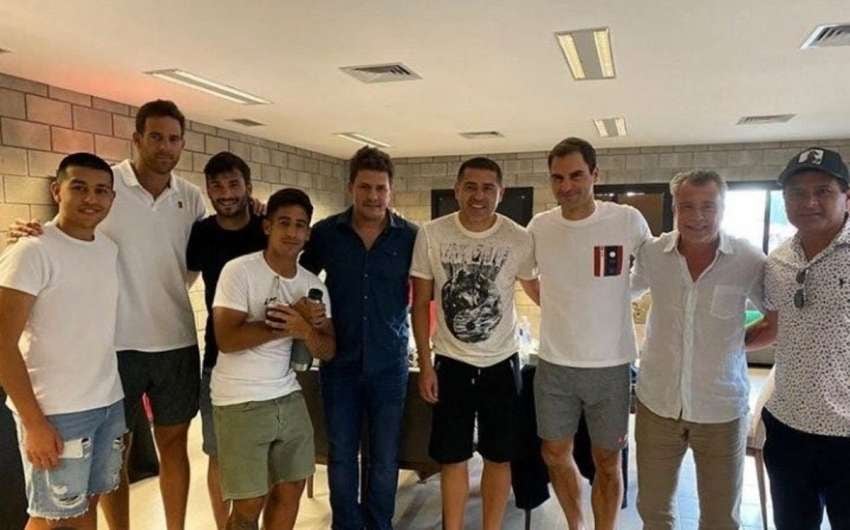 
    Román con amigos junto a Roger Federer.
   