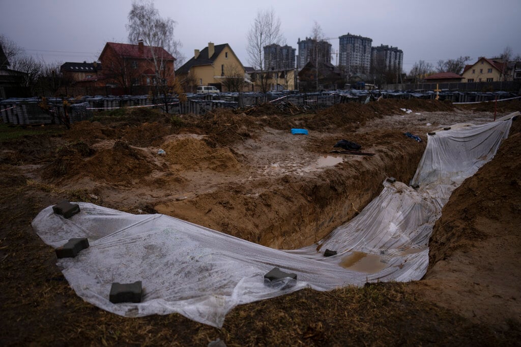 Una capa de plástico cubre una fosa común donde se encuentran enterrados civiles muertos durante la guerra contra Rusia, el domingo 10 de abril de 2022, en Kiev, Ucrania. (AP Foto/Rodrigo Abd)