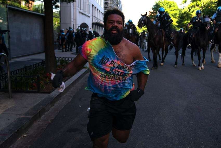 
AP | Un manifestante huye de una línea policial mientras la gente protesta cerca de la Casa Blanca.
   