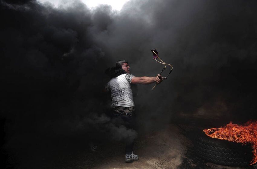 
Foto: AP | Un manifestante palestino lanza piedras a las tropas israelíes durante una protesta en la frontera de la Franja de Gaza con Israel, el viernes 20 de abril de 2018.
   