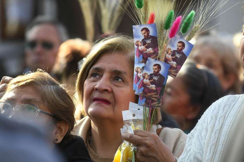 
Pedidos. Con espigas y estampitas en lo alto, esta creyente escucha una de las misas de ayer. | José Gutiérrez / Los Andes
   