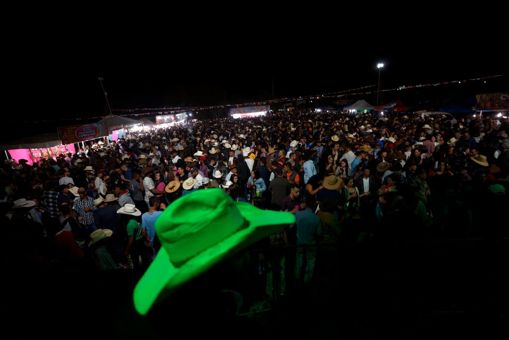 Varias personas participan en un baile por la tradición religiosa "Fiesta del Divino Espíritu Santo", en Pirenópolis, en el estado de Goias, Brasil, el domingo 29 de mayo de 2022. (AP Foto/Eraldo Peres)