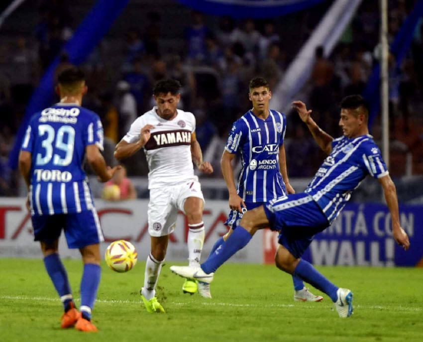 
Acosta, autor del segundo gol de Lanús, intenta pasar por entre Angileri, Cardona y Burgoa (39). | Diego Parés / Los Andes
   