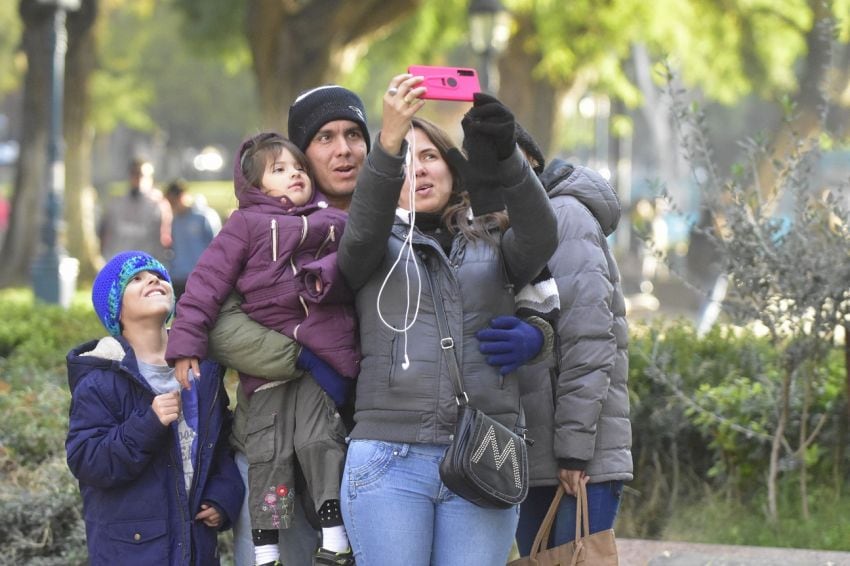 
Luna Rodríguez junto a su familia, de Venezuela se saca una selfie en la plaza Independencia | Diego Pares / Los Andes
   