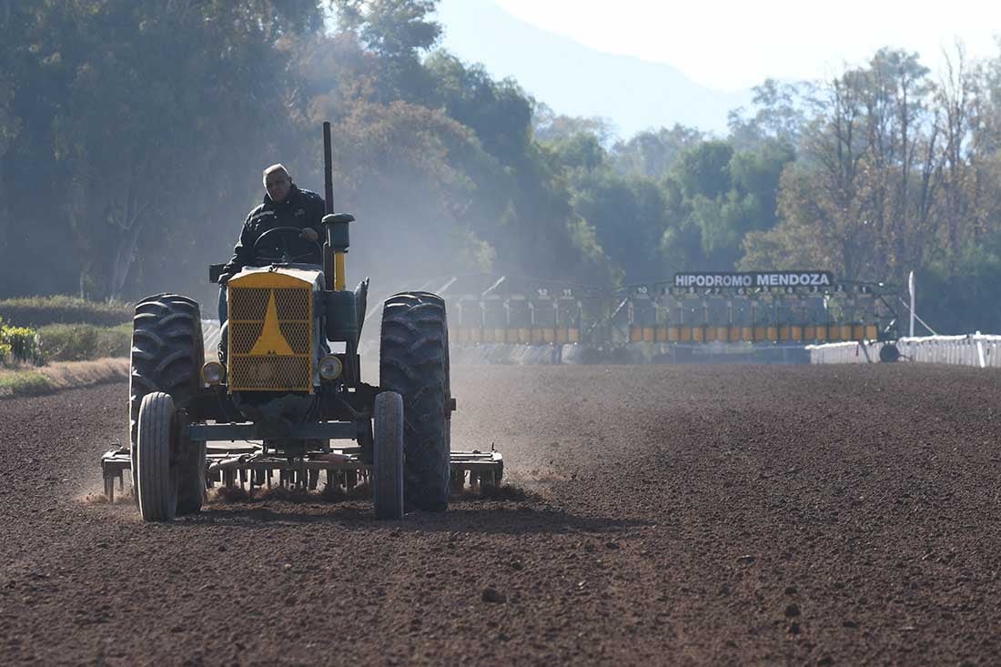 Antes del clásico personal del hipódromo trabaja en el emparejado del piso de la pista del hipódromo