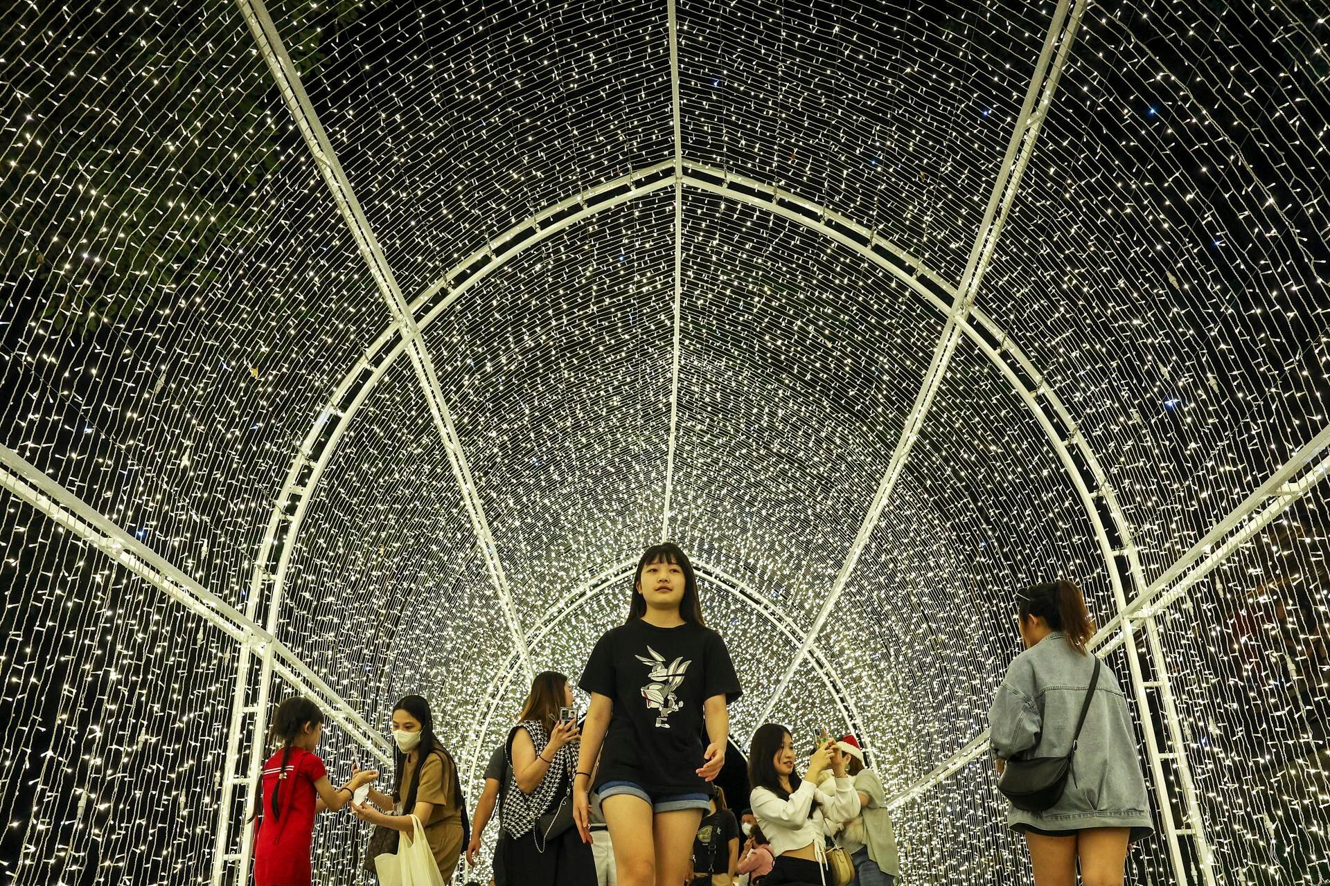 La gente camina dentro de un túnel de luz en Desa Park City, durante un 'Festival de la luz de fin de año de Parkcity' antes de las vacaciones de Navidad en Kuala Lumpur, Malasia, el 23 de diciembre de 2022. Christian comunidades de todo el mundo celebrarán la Navidad el 25 de diciembre, que es una fiesta anual que conmemora el nacimiento de Jesucristo. Foto: EFE/FAZRY ISMAIL