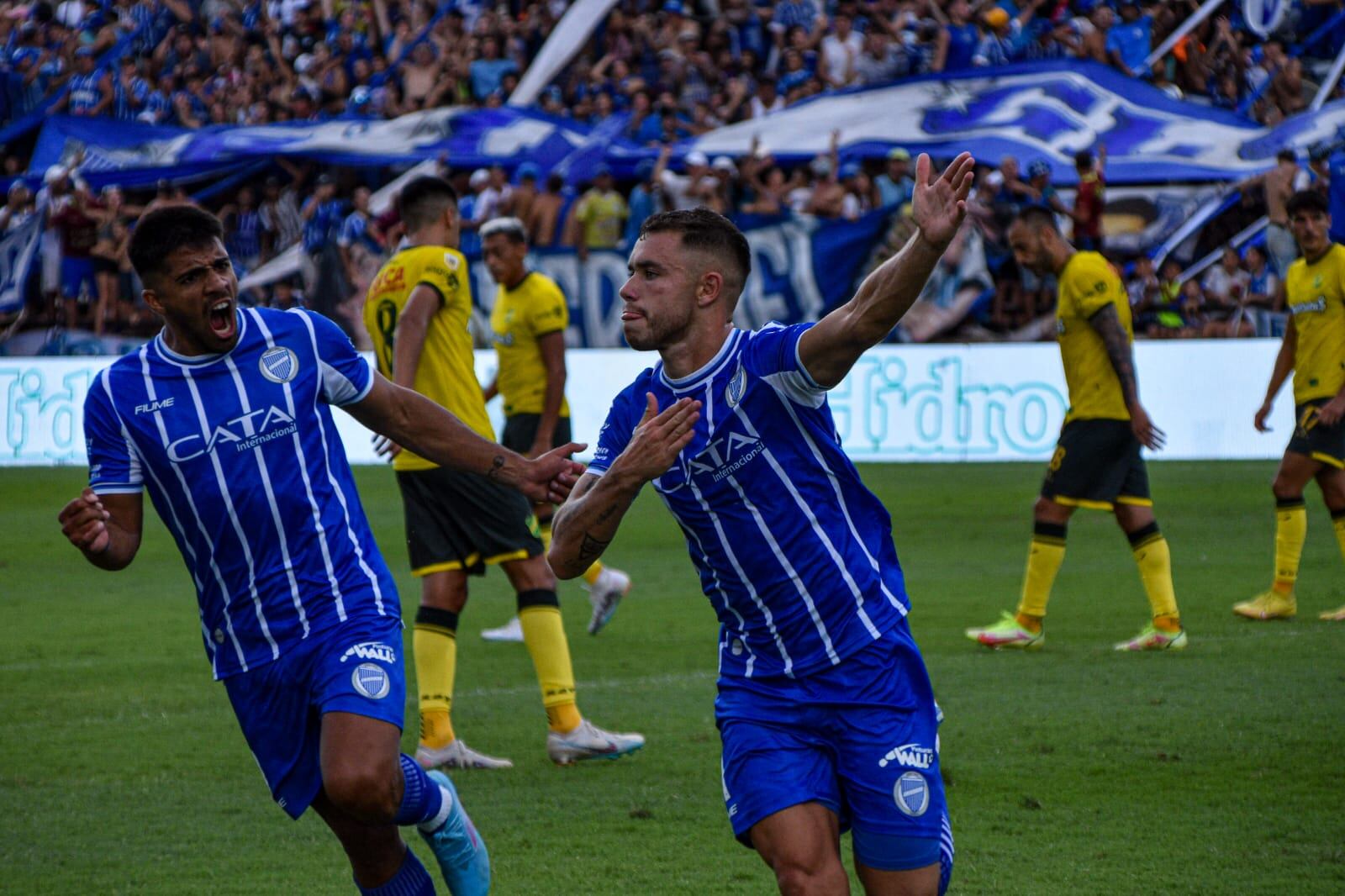 Tomás Conechny festeja su tanto de penal mientras Ulariaga lo persigue con la boca llena de grito de gol. Foto: Franco Monsalvo