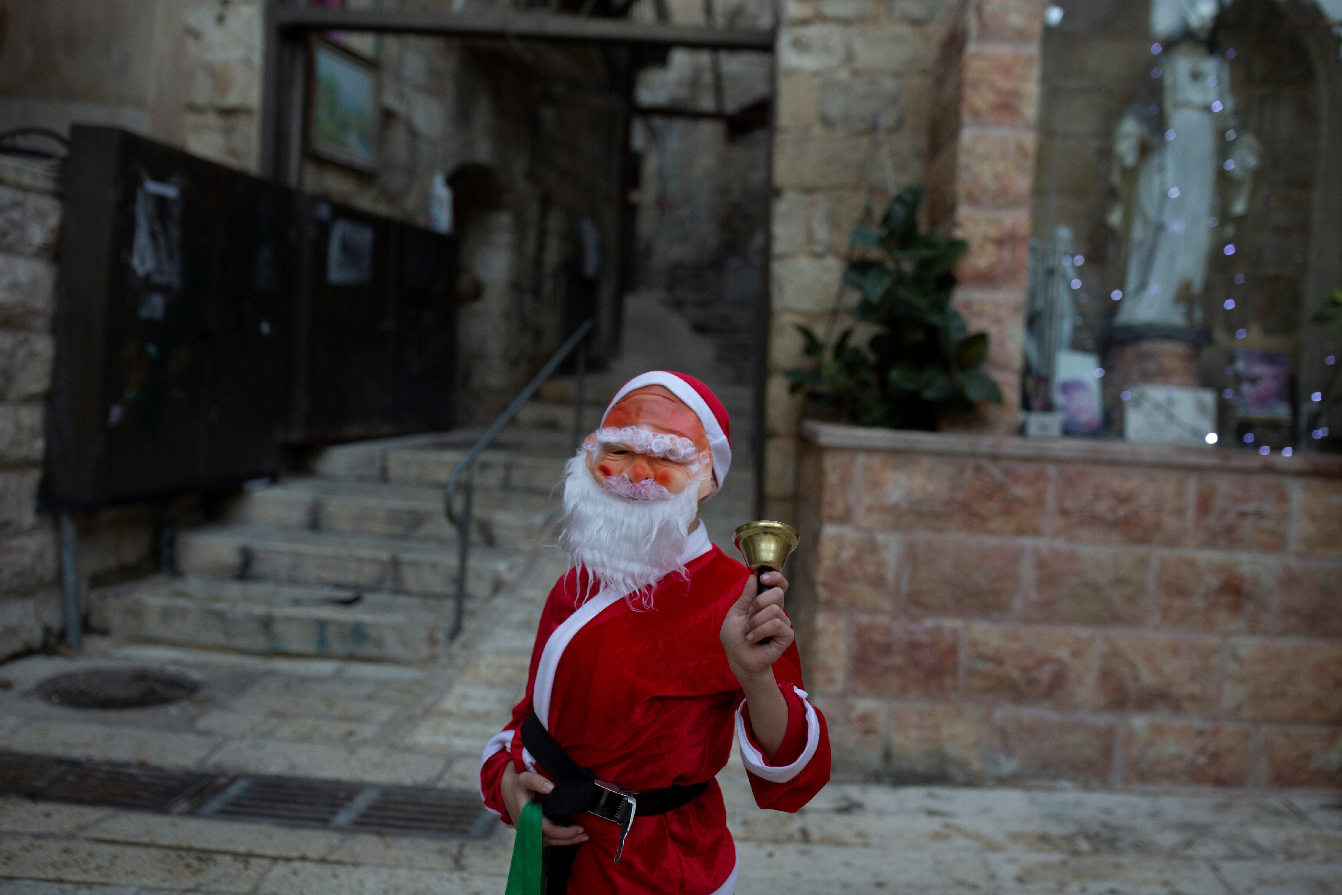 Un niño vestido como Santa Claus posa para un retrato de Nochebuena en el Barrio Cristiano de la Ciudad Vieja de Jerusalén.