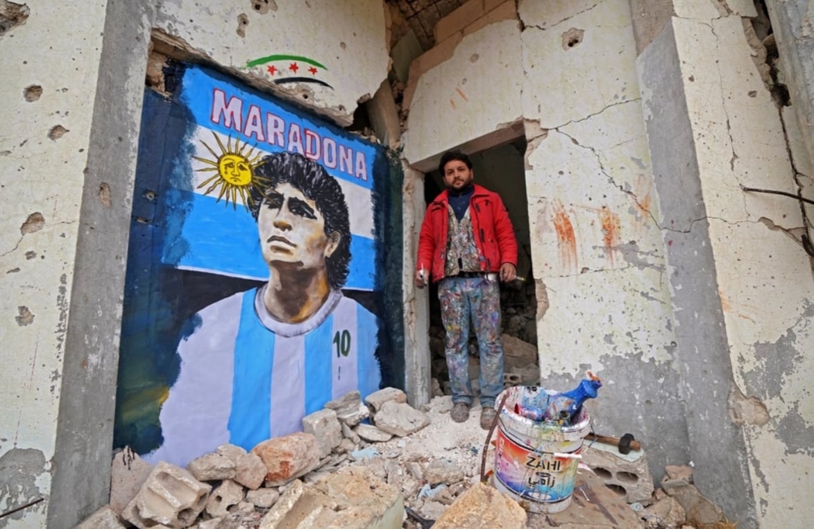 Un artista sirio realizó un mural con el rostro del '10' en una ciudad en ruinas. Foto AFP.