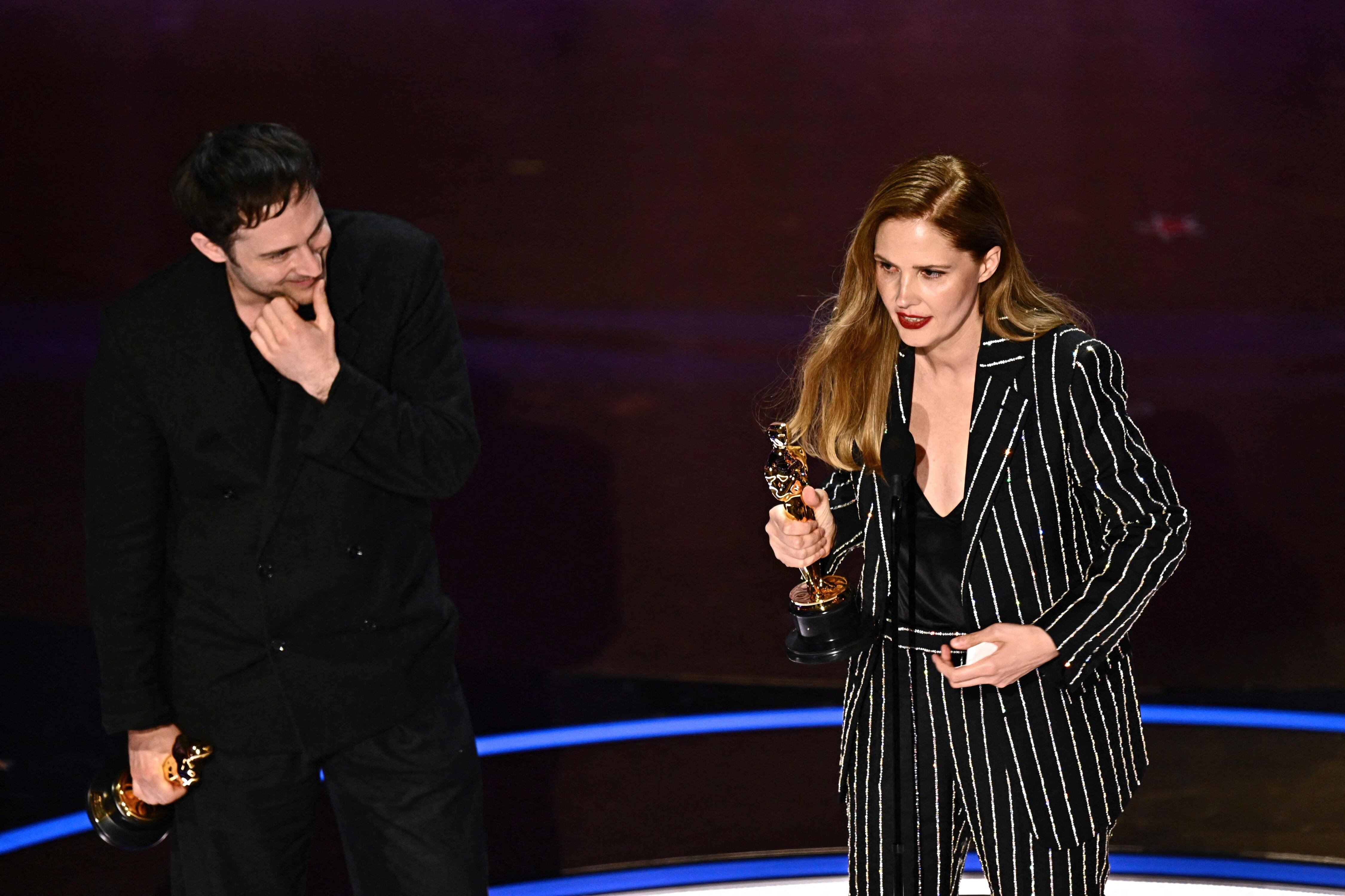 La directora y guionista francesa Justine Triet (derecha) y el director y guionista francés Arthur Harari aceptan el premio al Mejor Guión Original por "Anatomy of a Fall" en el escenario durante la 96a edición anual de los Premios de la Academia en el Dolby Theatre de Hollywood, California, el 10 de marzo de 2024. (Foto de Patrick T. Fallon / AFP)