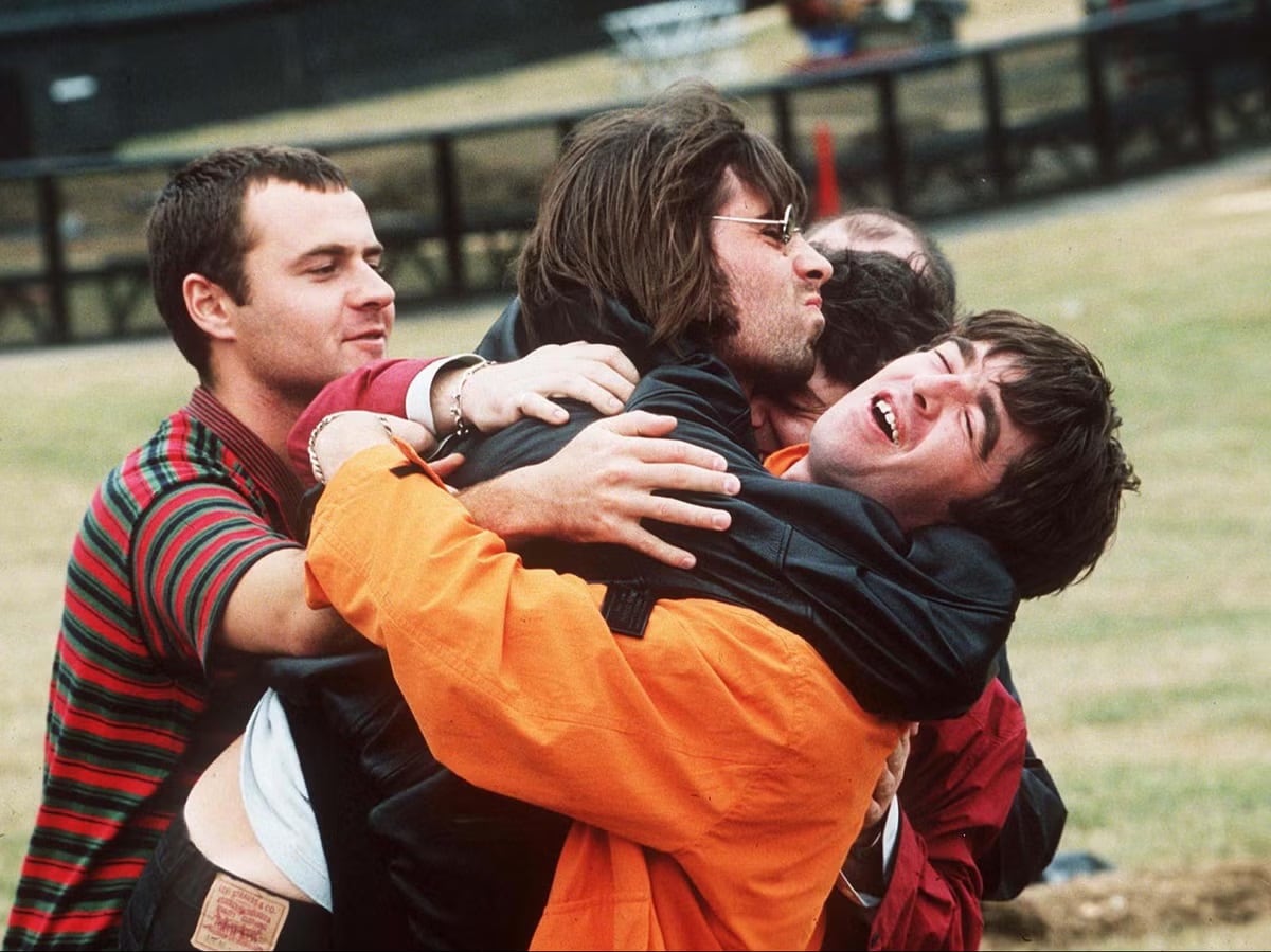 Alan White, Liam Gallagher y Noel Gallagher con su abrazo en el histórico show de Knebworth (1996) / Shutterstock