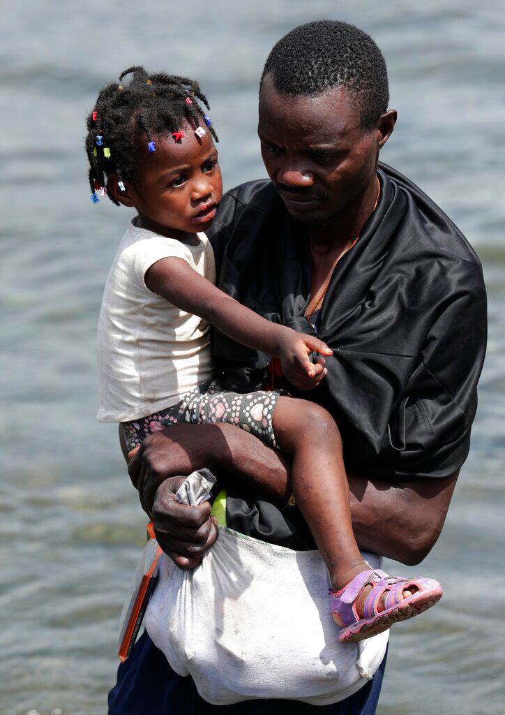 Un hombre pasa el río Tuquesa con un niño en brazos tras cruzar a pie la selva hasta Bajo Chiquito, en la provincia de Darien, Panamá