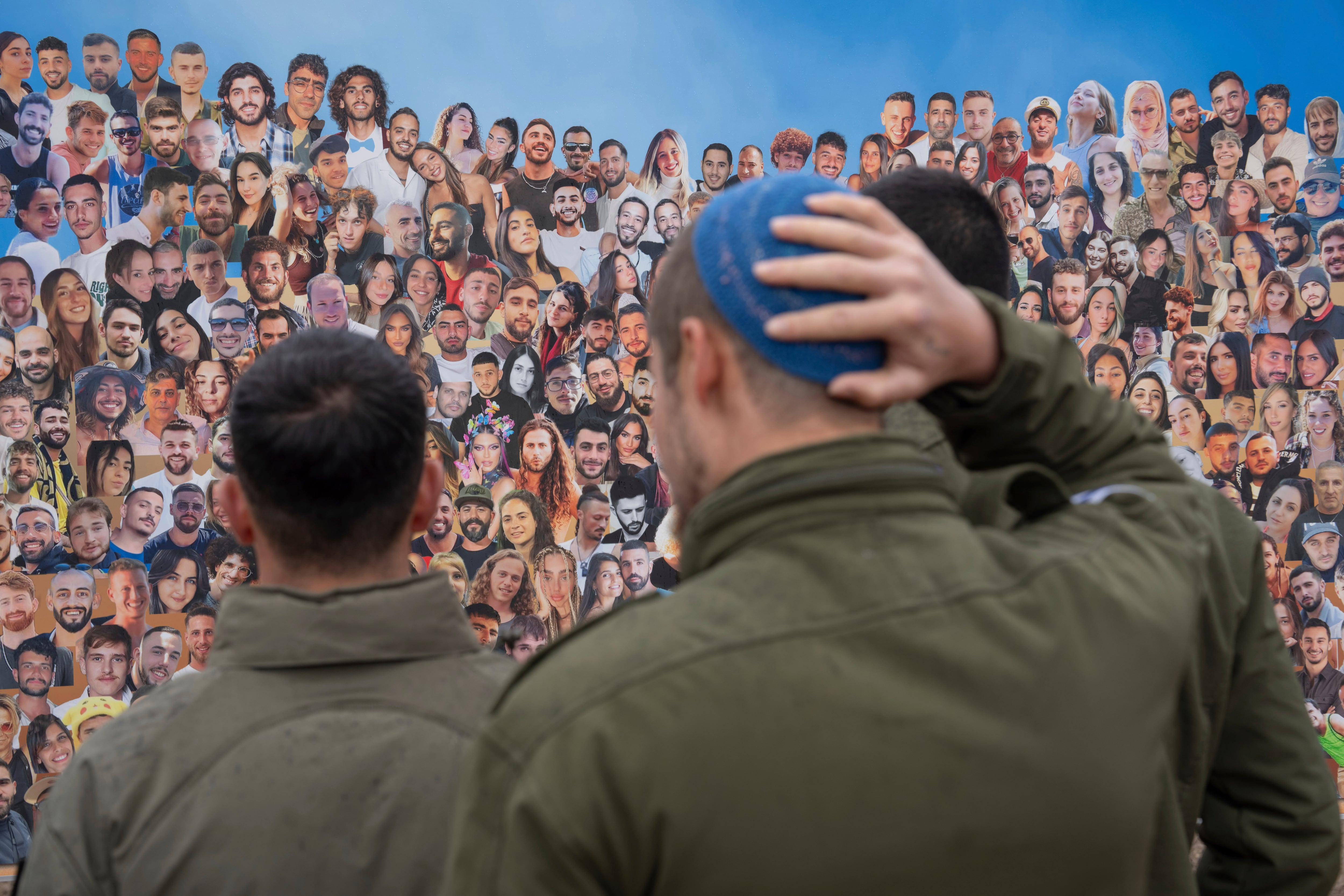 ARCHIVO - Soldados israelíes miran fotos de personas asesinadas por milicianos de Hamás  (Foto gentileza)