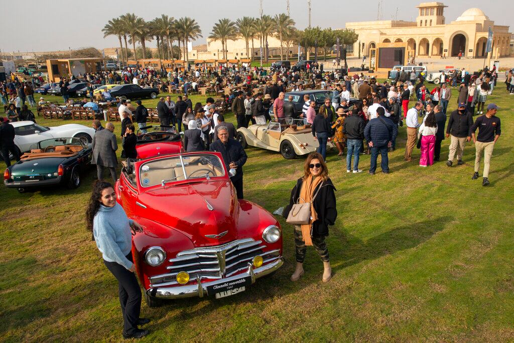 Entusiastas de los automóviles posan para la foto durante una muestra de coches clásicos el 19 de marzo de 2022, en El Cairo, Egipto. (AP Foto/Amr Nabil)