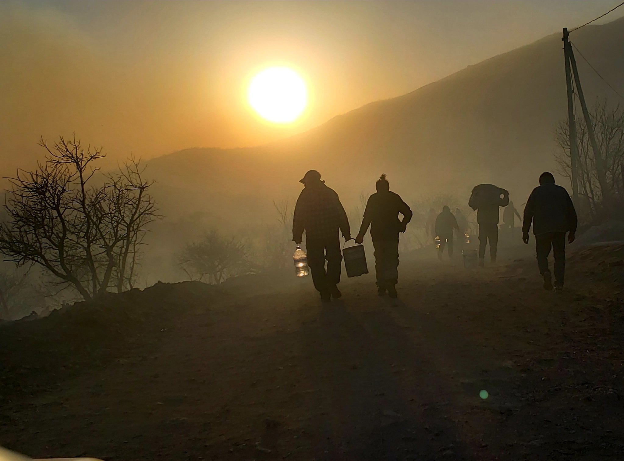 Vecinos brindan bidones con agua para apagar el incendio en Capilla del Monte.