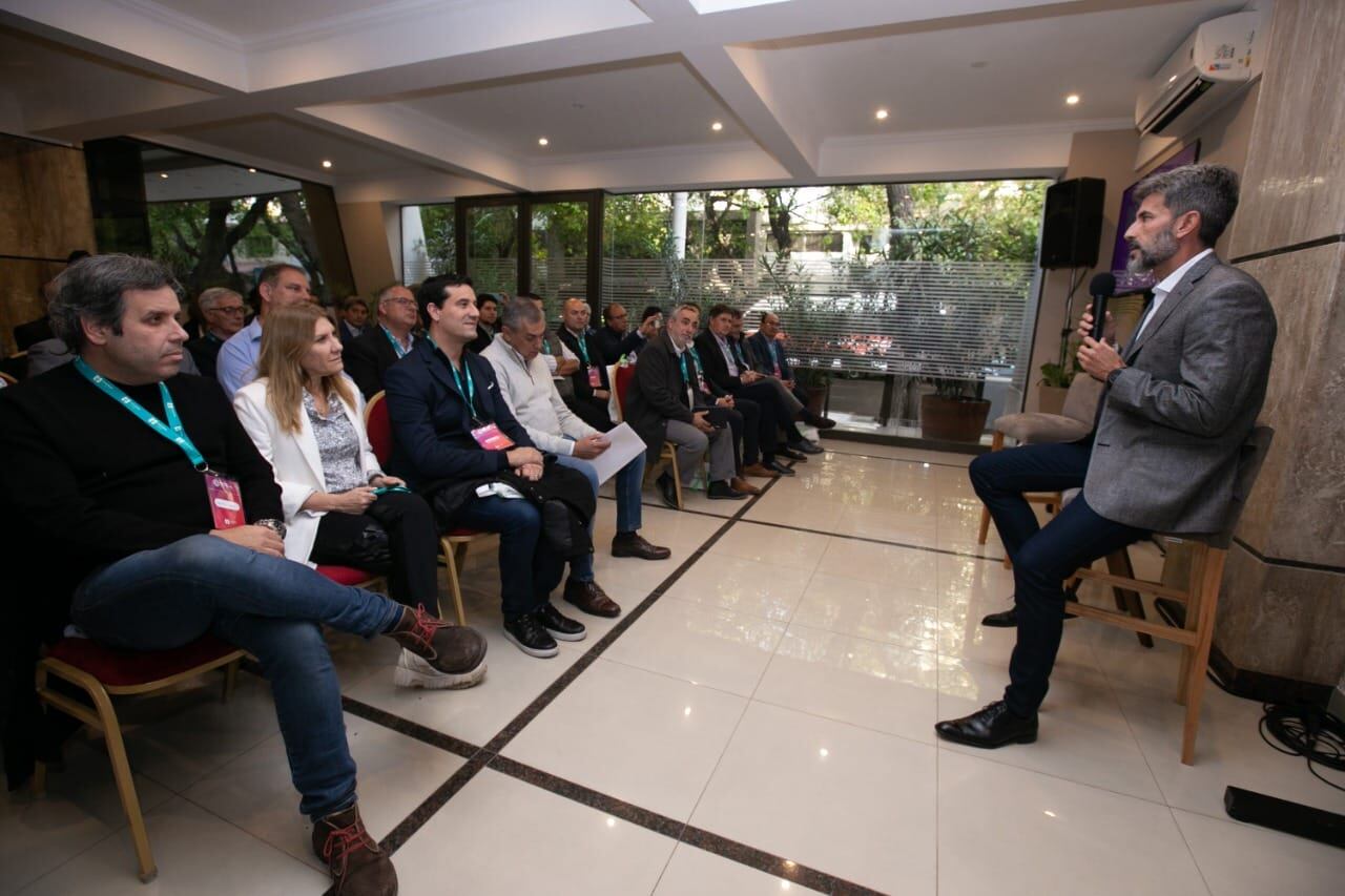 El intendente de la Ciudad, Ulpiano Suárez habla en el encuentro de intendentes. Gastón Manes y Maximiliano Abad escuchan en primera fila.