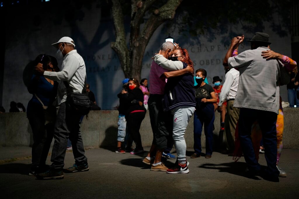 Varias parejas bailan salsa en una plaza en el centro de Caracas, Venezuela, el 5 de febrero de 2022. (AP Foto/Ariana Cubillos)