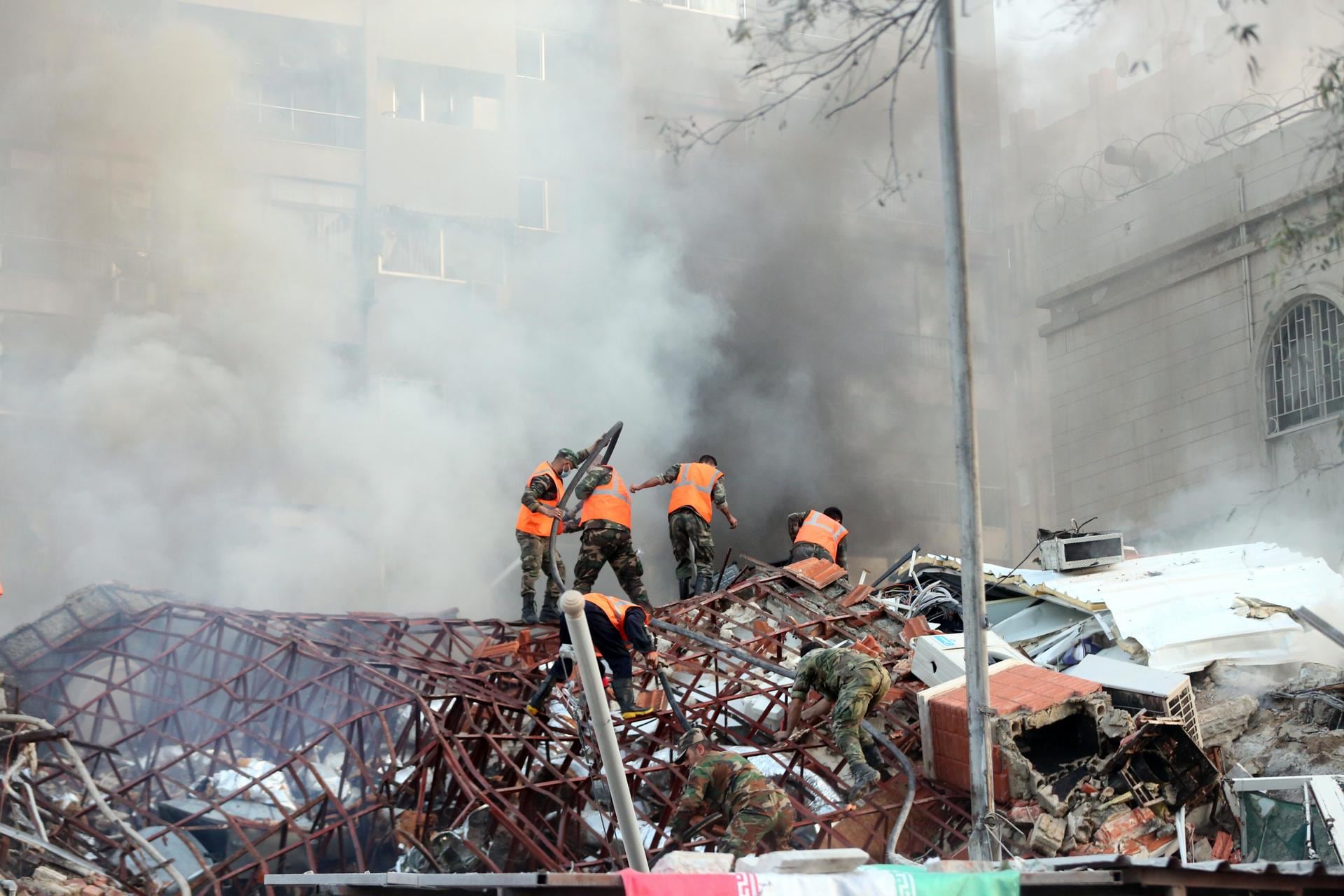 -FOTODELDÍA- Damasco, 01/04/2024.- Trabajadores de rescate en el lugar de un ataque aéreo en Damasco, Siria, el 1 de abril de 2024. Según la agencia de noticias árabe siria SANA, Israel lanzó un ataque aéreo contra el edificio del consulado iraní en Damasco. El consulado sufrió daños y el edificio contiguo quedó destruido. EFE/YOUSSEF DAFAWWI
