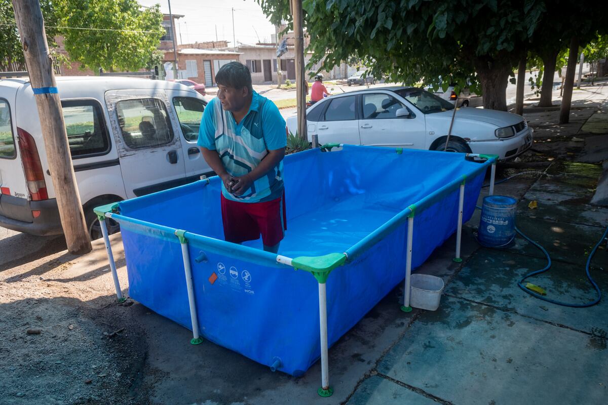 Omar Pinto limpia su pileta que armo en el frente de su casa en el barrio Pedro Molina.
