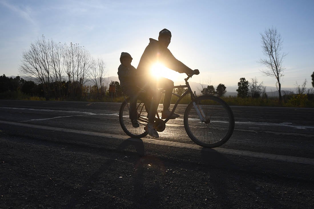 Un ciclista junto a su hijo por la ruta 40 rumbo a su casa cuando el sol emppieza a caer
foto: José Gutierrez / Los Andes 