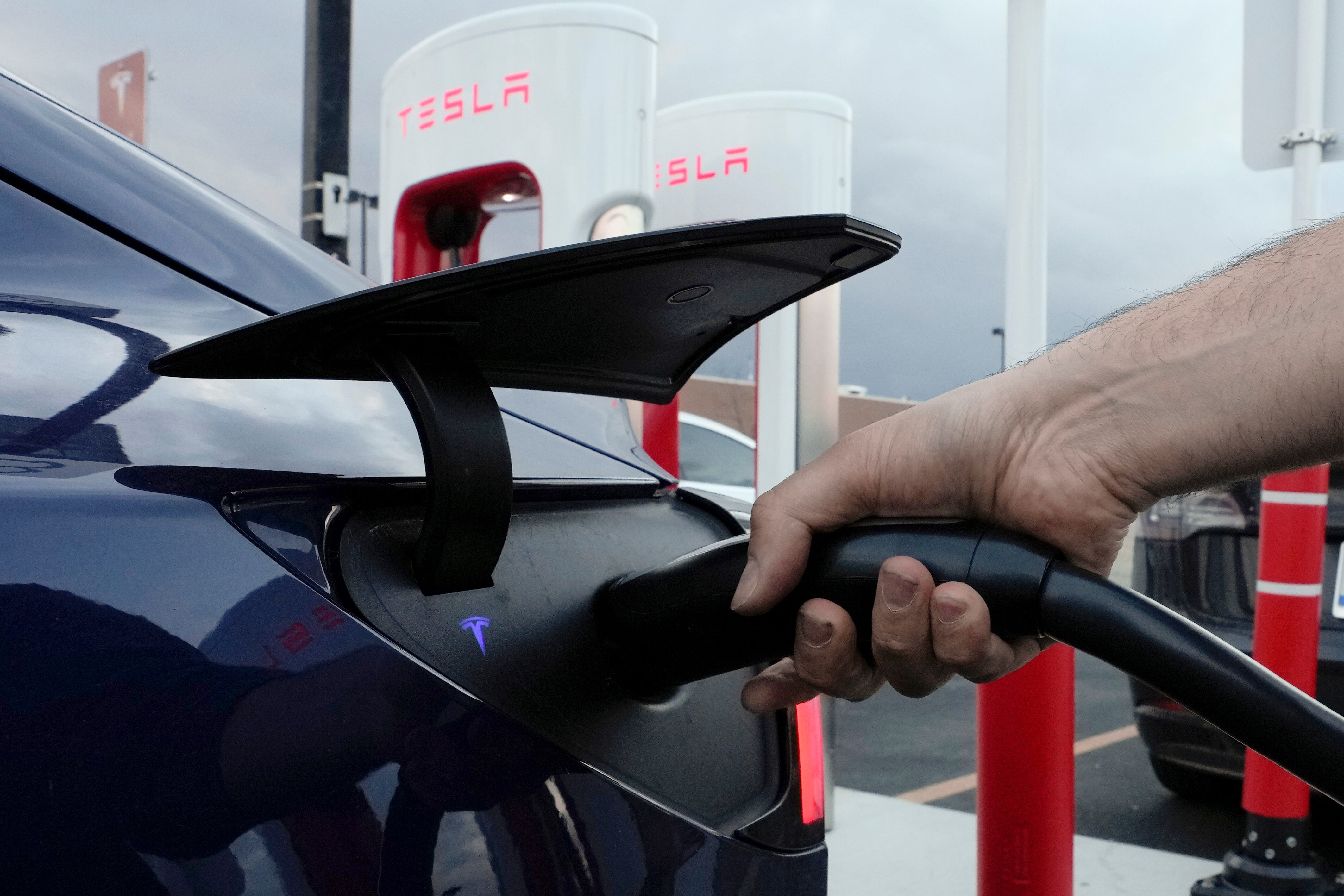 ARCHIVO - Un automovilista carga su vehículo eléctrico en una estación de Tesla en Detroit, el miércoles 16 de noviembre de 2022. (AP Foto/Paul Sancya, Archivo)