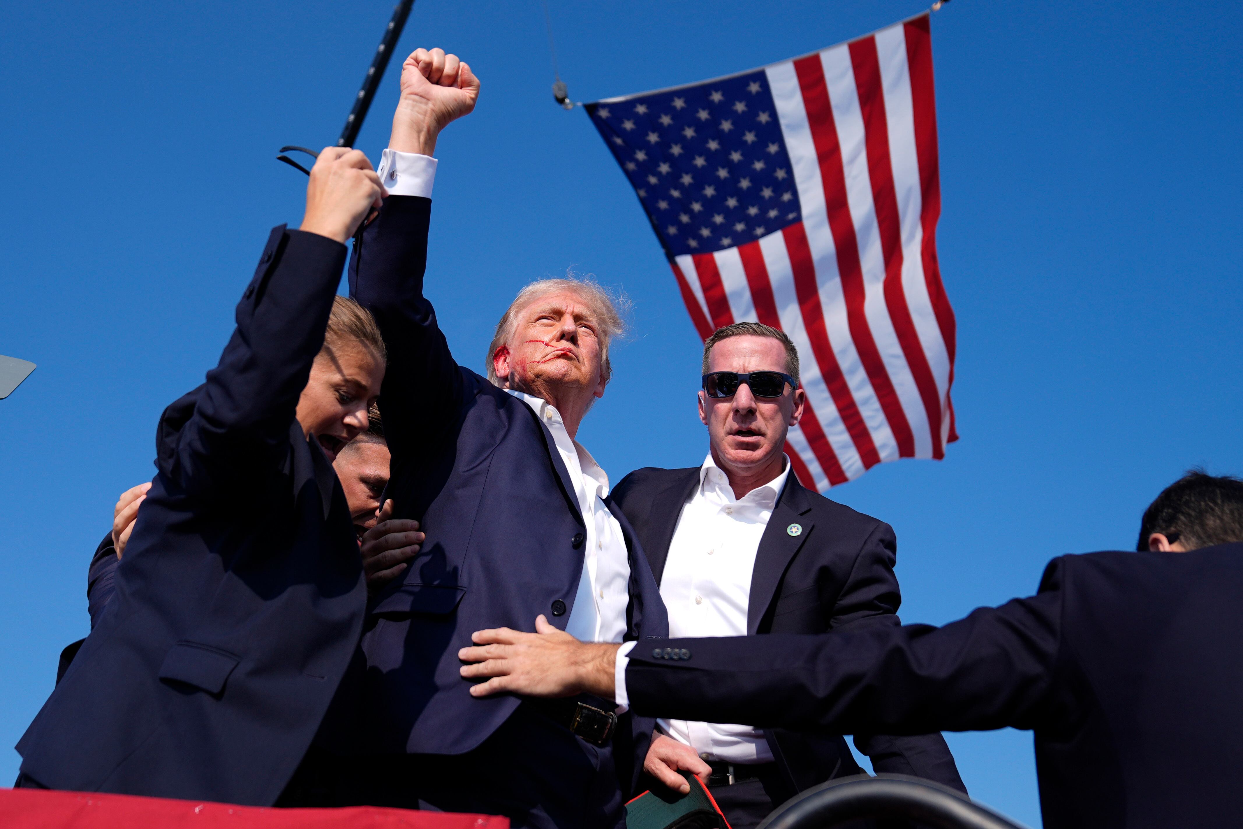 El virtual candidato republicano a la presidencia Donald Trump es rodeado por agentes del Servicio Secreto en un acto de campaña el sábado 13 de julio de 2024 en Butler, Pensilvania. (AP Foto/Evan Vucci)