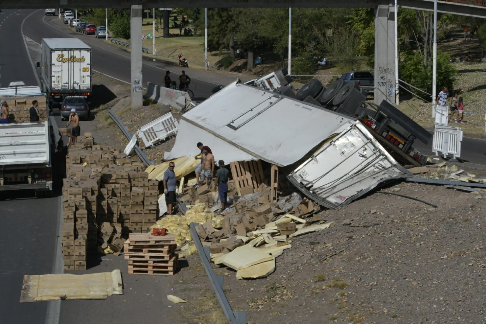 Un camión que transportaba papas congeladas volcó en el Acceso Este y la gente saqueó la mercadería. Foto: Orlando Pelichotti / Los Andes