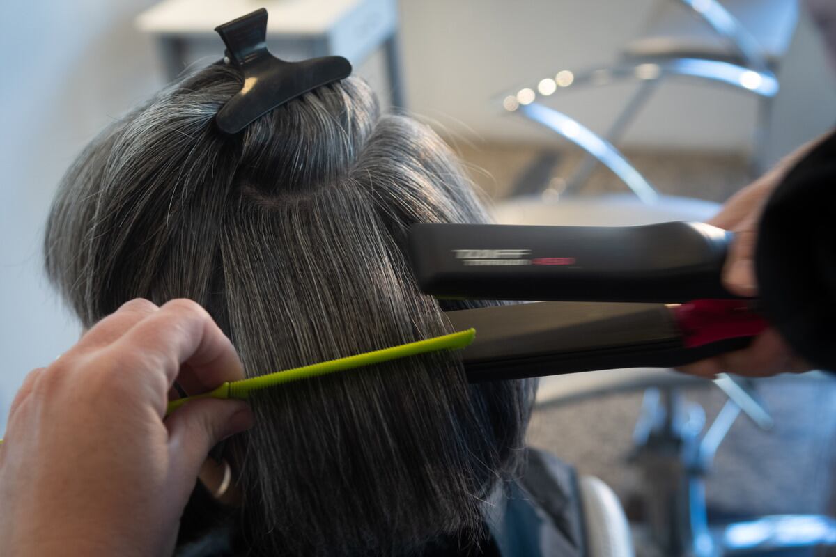 Natalia Falasco, en la peluquería Roller de Ciudad, peinando a su clienta Marta que luce sus canas con naturalidad.
