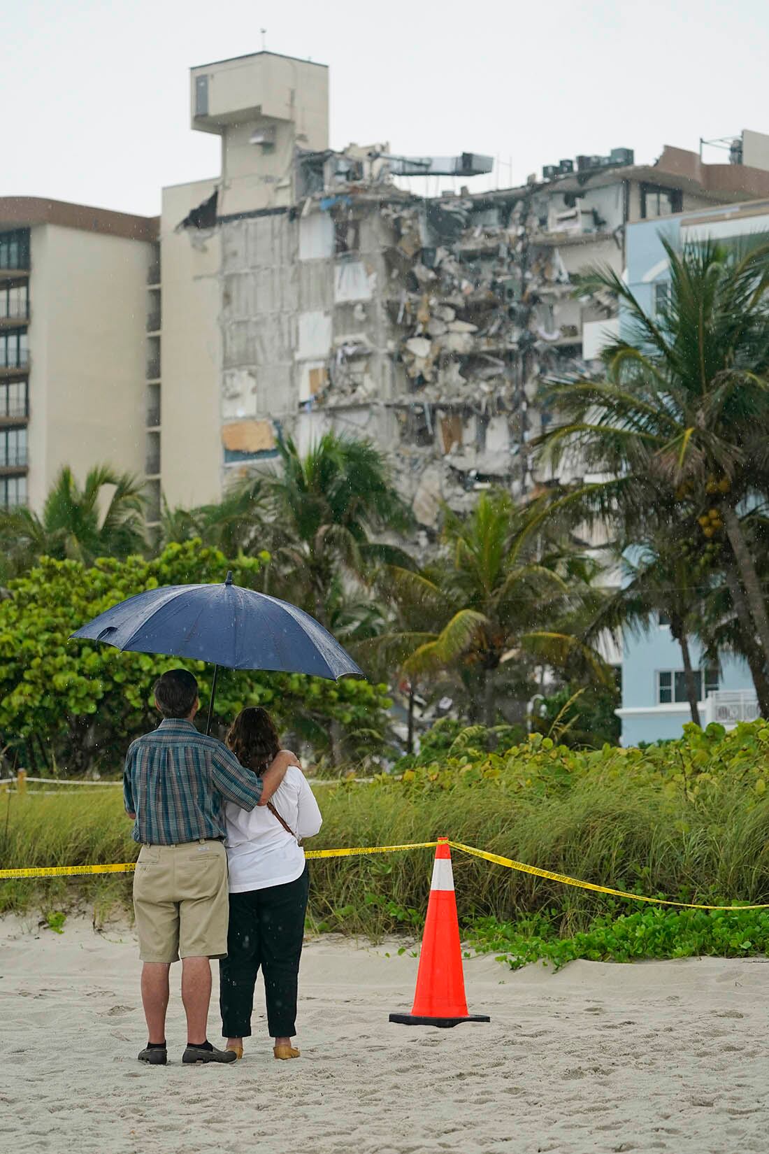 Una pareja observa los restos de un edificio.