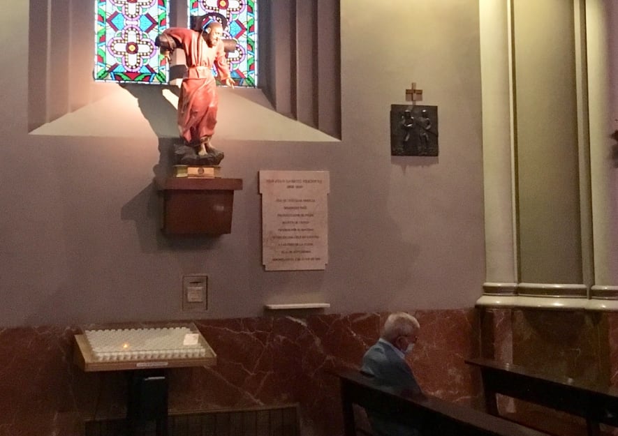 Un hombre con mascarilla en la basílica de La Milagrosa (Madrid), bajo la imagen de San Juan Gabriel Perboyre.