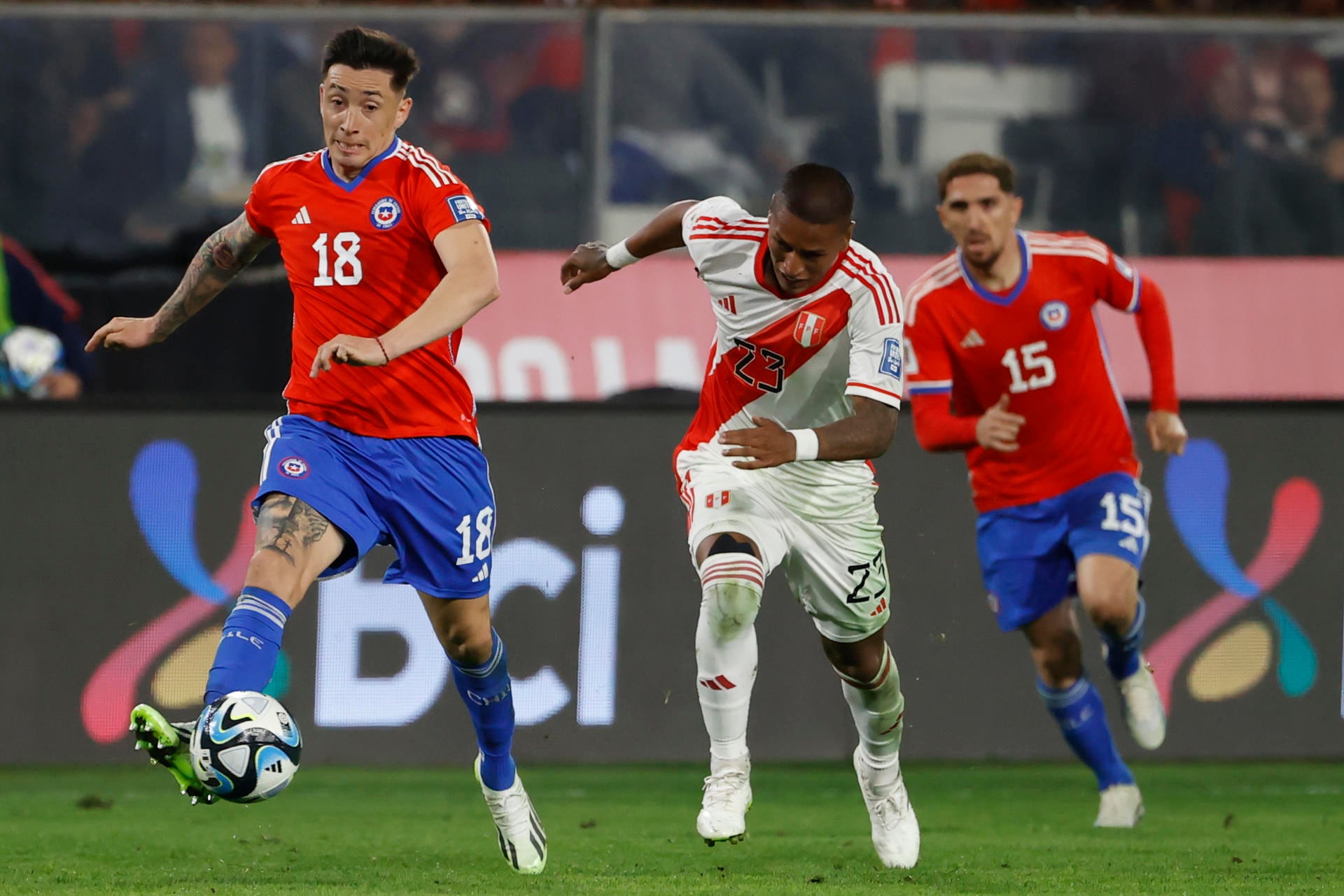 AMDEP523. SANTIAGO (CHILE), 12/10/2023.- Rodrigo Echeverría (i) de Chile disputa el balón con Pedro Aquino (c) de Perú hoy, en un partido de las Eliminatorias Sudamericanas para la Copa Mundial de Fútbol 2026 entre Chile y Perú en el estadio Monumental en Santiago de Chile (Chile). EFE/ Elvis González
