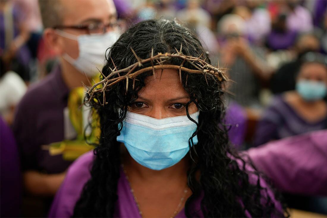 Una devota del Nazareno de San Pablo, con una corona de espinas y un hábito de color morado, reza en el interior de la basílica de Santa Teresa durante los actos de la Semana Santa, en Caracas, Venezuela, el 13 de abril de 2022. Tras dos años de restricciones por la pandemia del COVID-19, las puertas del conocido templo, donde está la venerada imagen, se abrieron el miércoles. (AP Foto/Ariana Cubillos)