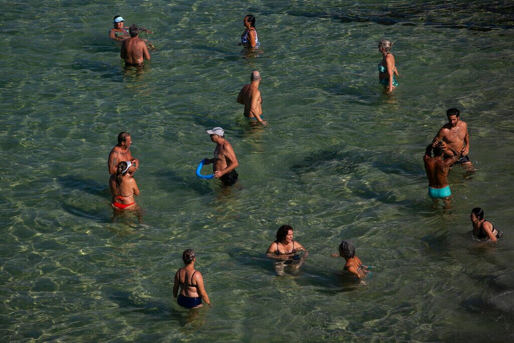 Varias personas se refrescan en el agua en la playa de Arpoador durante una ola de calor en Río de Janeiro, Brasil