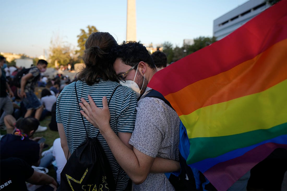 Miembros del Movimiento por la Integración y Liberación Homosexual celebran después de que los legisladores aprobaran una ley que legaliza el matrimonio y la adopción por parejas del mismo sexo, en Santiago, Chile, el martes 7 de diciembre de 2021. (AP Foto/Esteban Felix)