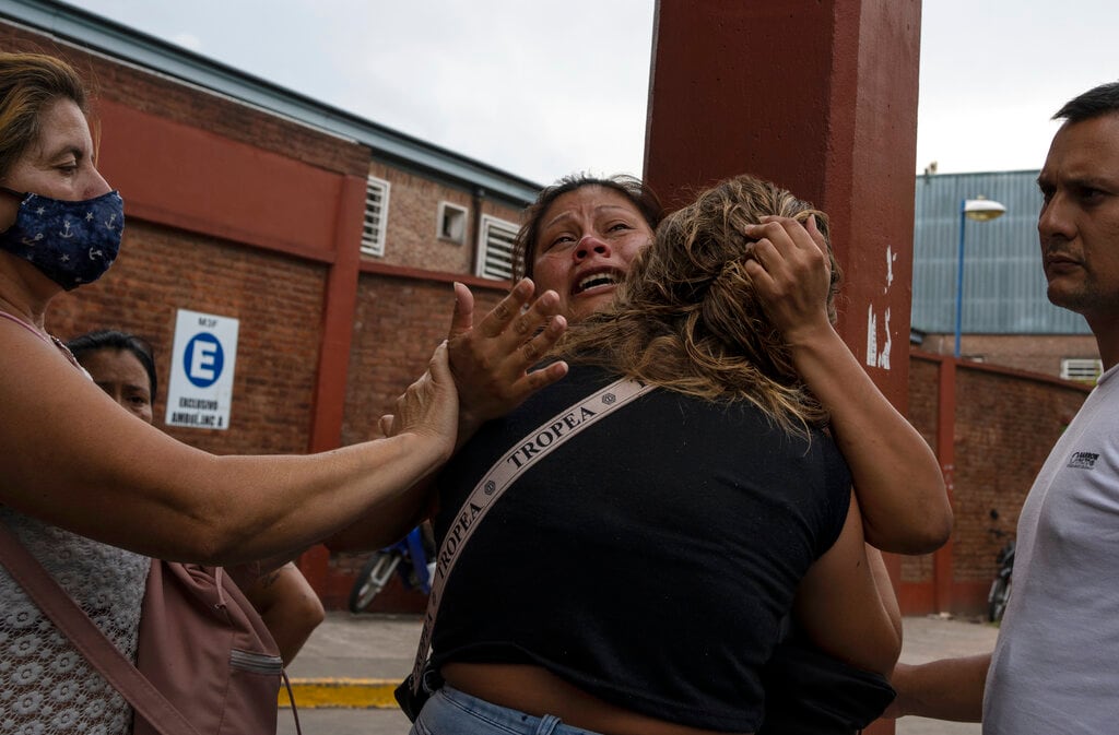 Una mujer recibe consuelo al enterarse de la muerte de su hermano tras consumir cocaína adulterada, en el exterior del hospital Bocalandro, cerca del vecindario Puerta 8, un suburbio al norte de Buenos Aires, Argentina, el 4 de febrero de 2022. Una partida de cocaína ha matado a al menos 23 personas y llevó al hospital a muchas más en Argentina, según la policía. (AP Foto/Rodrigo Abd)