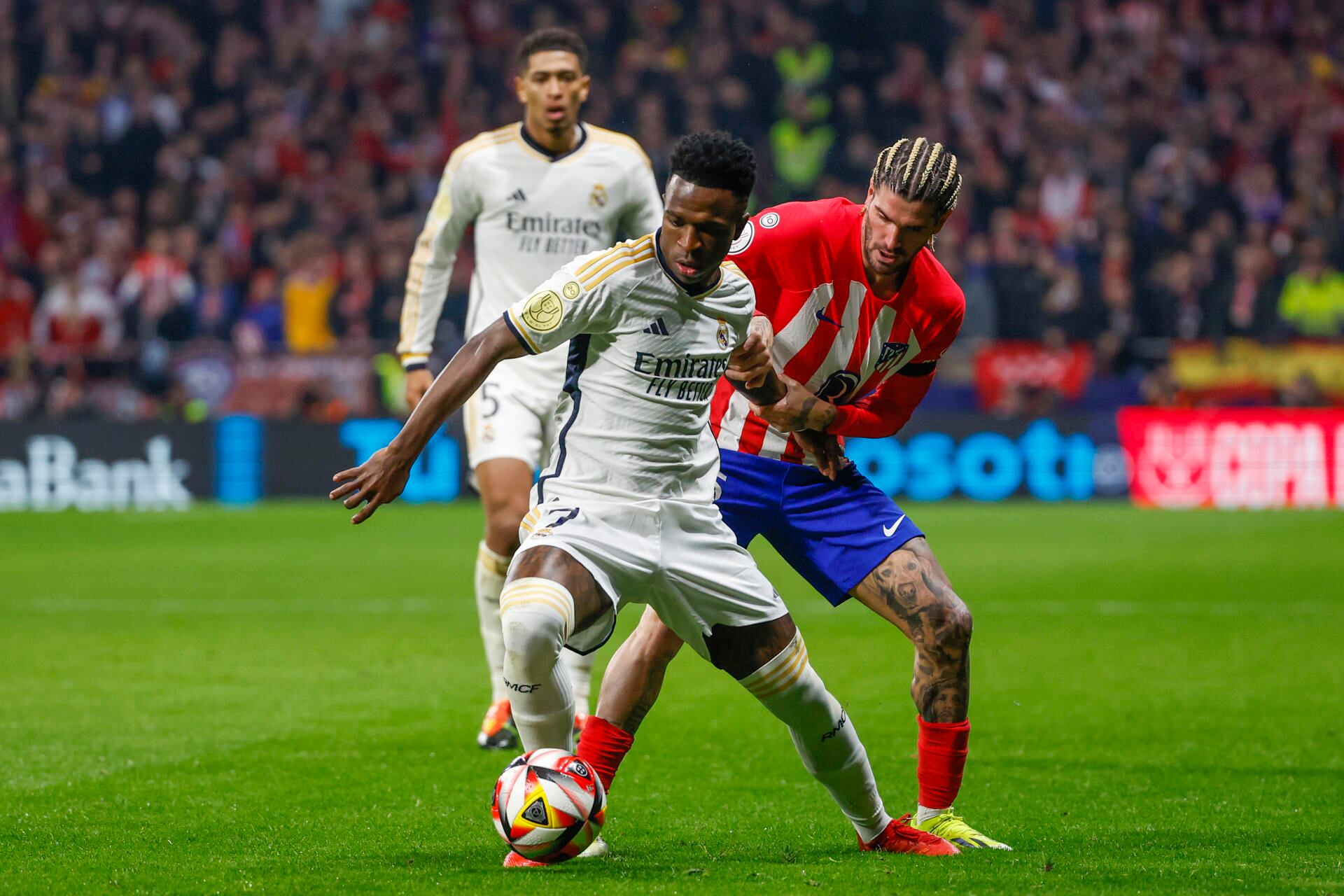 El delantero del Real Madrid Vinicius Jr. (i) lucha con Rodrigo de Paul, del Atlético de Madrid, durante el partido de octavos de final de la Copa del Rey de fútbol entre Atlético de Madrid y Real Madrid, este jueves en el estadio Cívitas Metropolitano. EFE/Juanjo Martín