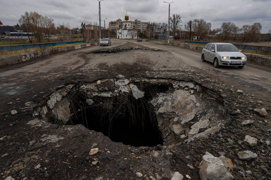 Vehículos circulan cerca de un puente que resultó dañado por un ataque ruso hace algunas semanas, el domingo 10 de abril de 2022, en la localidad de Makarov, en la región de Kiev, Ucrania. (AP Foto/Petros Giannakouris)