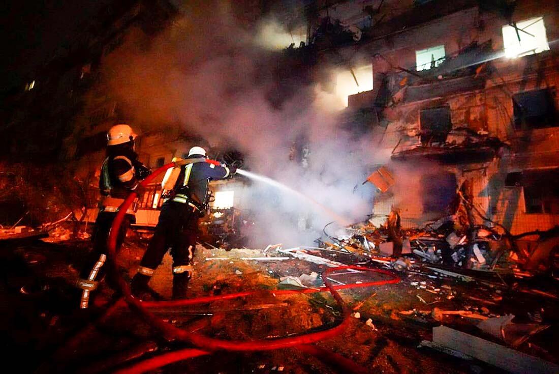 Bomberos inspeccionan los daños en un edificio luego de un ataque con cohetes en la ciudad de Kiev (AP)