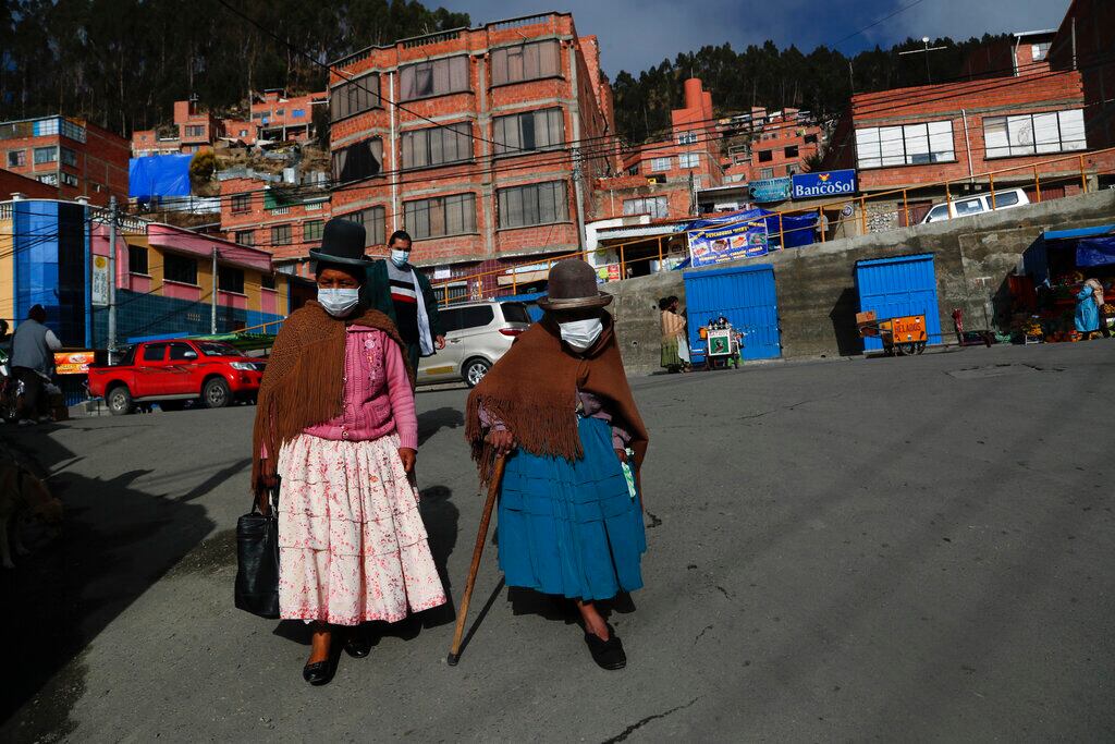 Mujeres caminan en una calle antes de la apertura de las mesas de votación en El Alto, Bolivia.