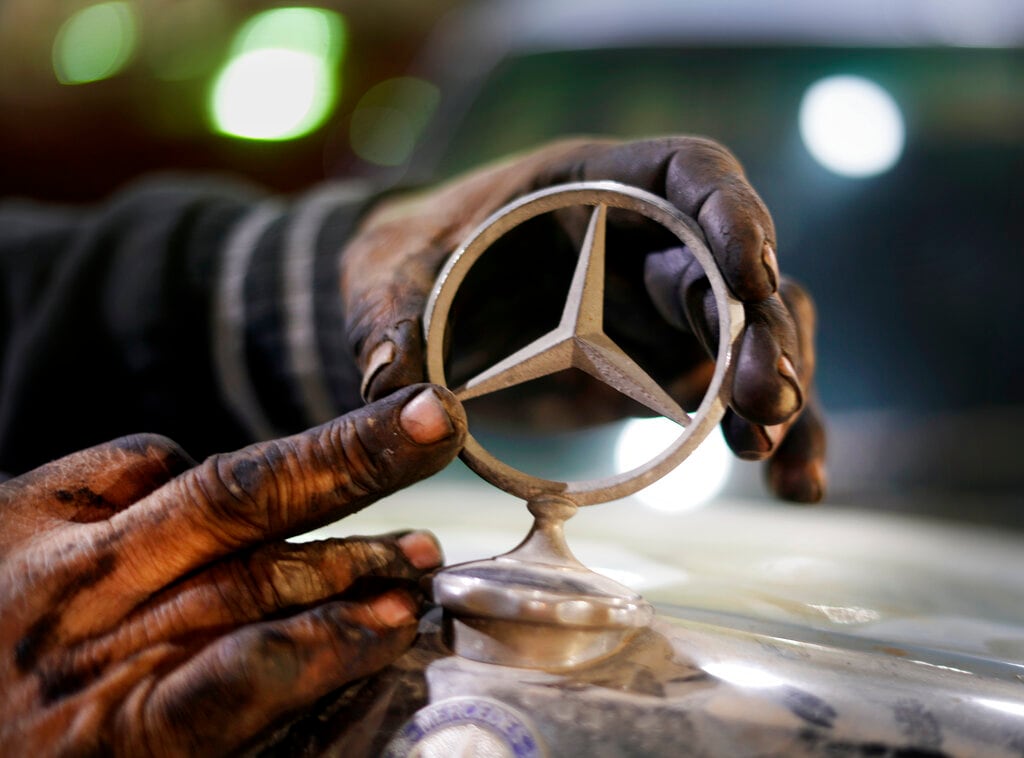 Un mecánico sustituye el logotipo de un Mercedes 1976 en un lote de un coleccionista privado el viernes 8 de abril de 2022, en la ciudad de El Saff, en la gobernación de Giza, en las afueras de El Cairo. Mohamed Wahdan, un empresario egipcio y coleccionista de vehículos clásicos, dice haber acumulado más de 250 automóviles vintage, antiguos y clásicos en los últimos 20 años. (AP Foto/Amr Nabil)