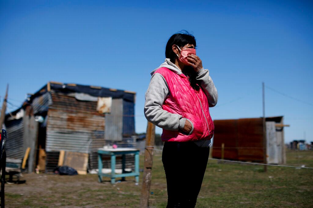 Cecilia Ávila se encuentra frente a la casa improvisada donde vive en un campamento de ocupantes ilegales en Guernica, provincia de Buenos Aires, Argentina