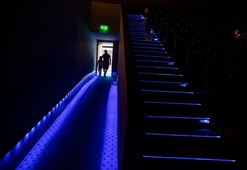 Dos personas entrar a un cine en el primer día de su reapertura, en los cines Cinépolis de Santiago, Chile