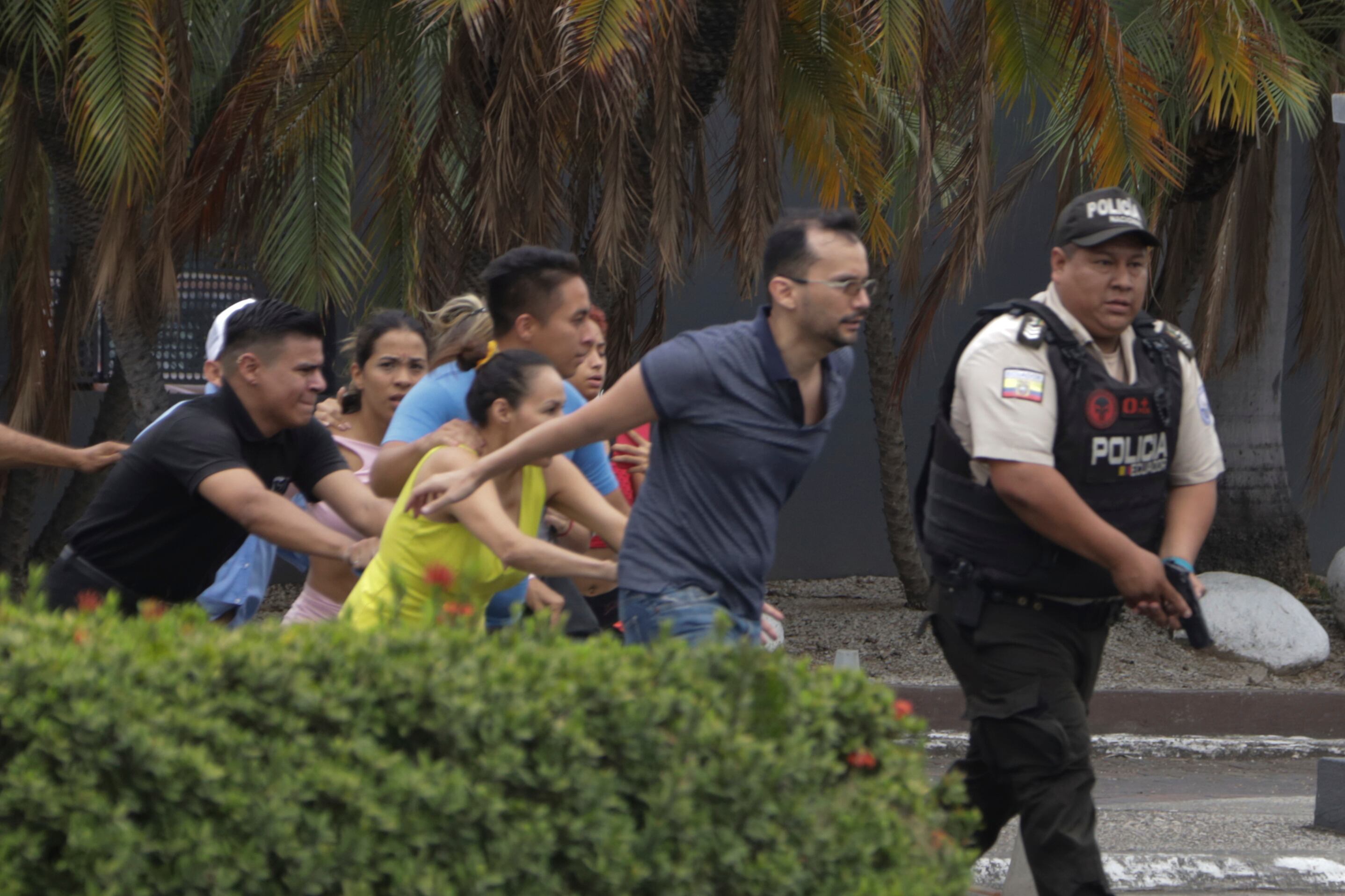 La policía evacúa a personal del canal TC Televisión después de que un grupo armado y encapuchado irrumpiera en plena transmisión en directo, en Guayaquil, Ecuador (AP Foto/César Muñoz)