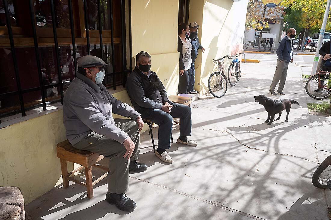 Vecinos esperan en la vereda antes de apostar unos números en la quiniela. 
